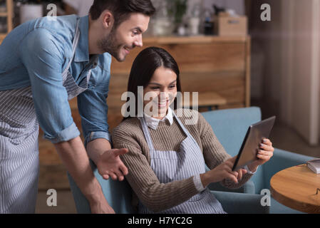 Satisfied overjoyed couple laughing and using tablet Stock Photo