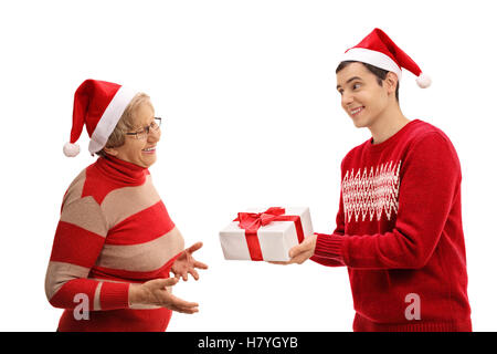 Young man giving a christmas present to an elderly lady isolated on white background Stock Photo