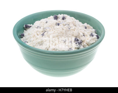 Imitation blueberry muffin mix in a green bowl isolated on a white background. Stock Photo