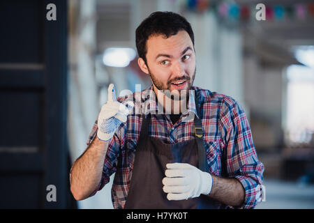 Worker show his finger in cloth glove explaining something to someone Stock Photo