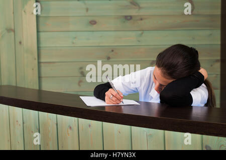 The female doctor sits at a table having closed eyes for fatigue Stock Photo