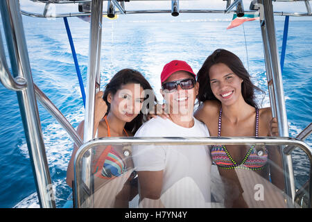 Two young women posing with male captain on small fishing boat. Big smiles. Banderas Bay Pacific Ocean, Puerto Vallarta, Mexico Stock Photo