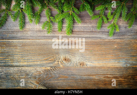Christmas fir tree or spruce branches on wooden background, top view Stock Photo