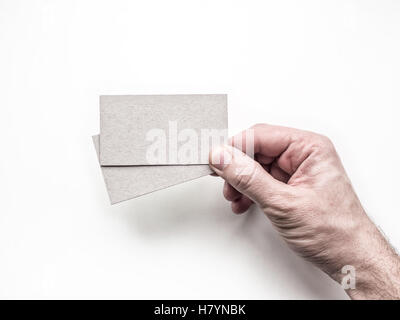 Closeup of hand holding two business cards on the white wall, Mockup Stock Photo