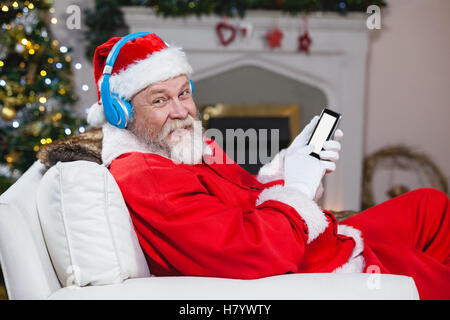 Santa claus using mobile phone at home Stock Photo