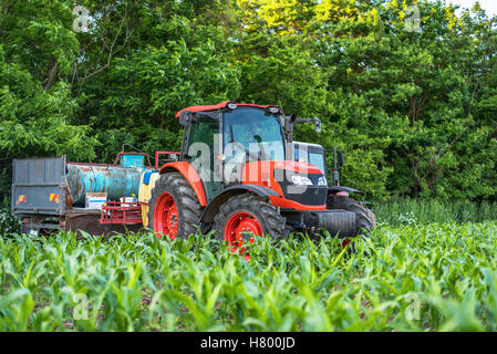 Red tractor on a green field Stock Photo