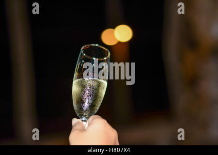 Wine glass on  hand .with defocused lights  in background. Stock Photo