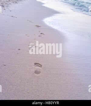 The footsteps on the wet sand will be washed by the waves, El Kantaoui, Tunisia. Stock Photo