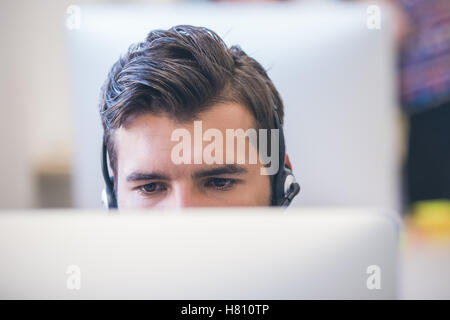 Thoughtful young programmer coding on computer Stock Photo