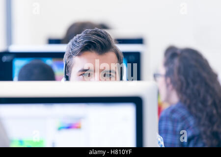 Thoughtful young programmer coding on computer Stock Photo