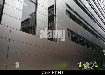 Uniformed personnel walk past UBS HQ in Broadgate, London Stock Photo