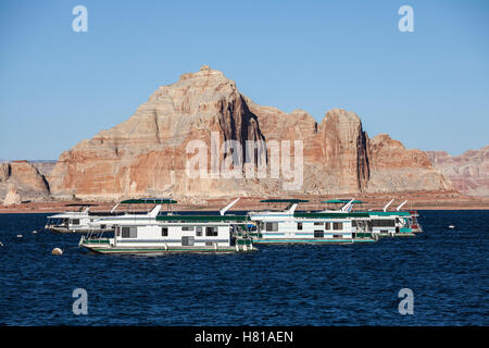 Desert sandstone peaks and houseboats on Lake Powell in the Glen Canyon National Recreation Area. Stock Photo