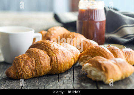 Tasty buttery croissants on old wooden table. Stock Photo