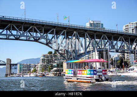 Vancouver, Canada - July 26, 2010: An Aquabus ferry approaches Granville Island Bridge on False Creek in downtown Vancouver. The Stock Photo