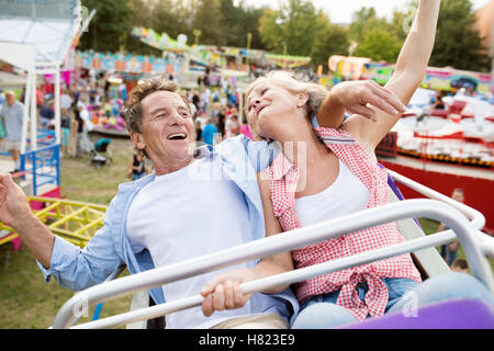 Senior couple on a ride in amusement park Stock Photo
