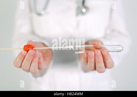 Female forensic technician collecting biological specimen in DNA tube, close up of womans hands in white uniform with sampled co Stock Photo