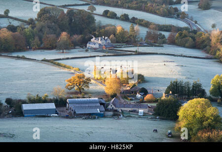 House and farmland in the valley of Downham Hill from Uley Bury on a cold frosty autumn morning just after sunrise. Gloucestershire, England Stock Photo
