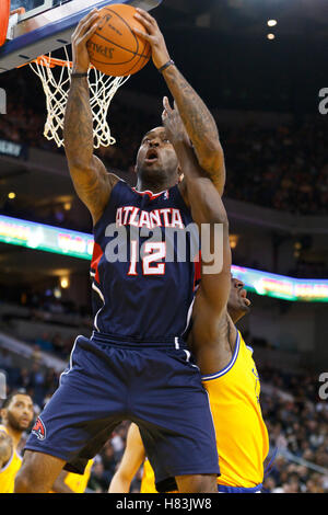 February 25, 2011; Oakland, CA, USA;  Atlanta Hawks center Josh Powell (12) grabs a rebound past Golden State Warriors power forward Ekpe Udoh (right) during the fourth quarter at Oracle Arena. Atlanta defeated Golden State 95-79. Stock Photo