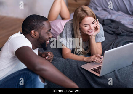 Young couple using laptop in bedroom Stock Photo