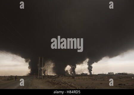 Qayyarah, Niniveh, Iraq. 8th Nov, 2016. Smoke from a burning oil facility fills the sky over the Iraqi town of Qayyarah. Oil wells in and around the town of Qayyarah, Iraq, we set alight in July 2016 by Islamic State extremists as the Iraqi military began an offensive to liberated the town.For two months the residents of the town have lived under an almost constant smoke cloud, the only respite coming when the wind changes. Credit:  ZUMA Press, Inc./Alamy Live News Stock Photo