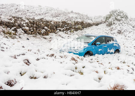 Leeds, West Yorkshire, UK. 9th Nov, 2016. Car rolls off the road above in snowy conditions, early morning on Cow & Calf Moor Road, Ilkley, UK. Footprints indicate driver walked away. Credit:  Rebecca Cole/Alamy Live News Stock Photo