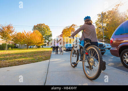 Merrick, New York, USA. Nov. 08, 2016. On Election Day, a family, a mother, father, and two young daughters, rode their bicycles to the polling place at the Park Avenue Elementary school are then were walking their bikes on the front sidewalk as they left the school property. Stock Photo