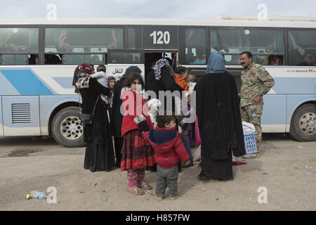 Mosul, Nineveh, Iraq. 10th Nov, 2016. 10/11/2016. Mosul, Iraq. A young girl looks back she and other families, escaping from areas within the city where fighting between Iraqi Security Forces and Islamic State militants is taking place, board a bus in the city's Gogjali District. The bus, provided by the Iraqi Army, will take them to the safety of a refugee camp in Iraqi-Kurdistan. Credit:  ZUMA Press, Inc./Alamy Live News Stock Photo