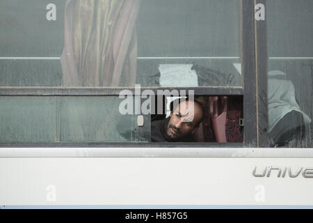 Mosul, Nineveh, Iraq. 10th Nov, 2016. 10/11/2016. Mosul, Iraq. An Iraqi man looks from a bus window for a friend as he and other families, escaping from areas within the city where fighting between Iraqi Security Forces and Islamic State militants is taking place, wait to be evacuated by the Iraqi Army from the city's Gogjali District. Credit:  ZUMA Press, Inc./Alamy Live News Stock Photo