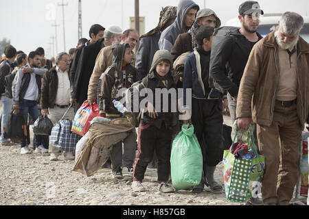 Mosul, Nineveh, Iraq. 10th Nov, 2016. 10/11/2016. Mosul, Iraq. Iraqi men, holding bags containing their possessions, wait in line as the prepare to board a bus that will evacuate them from Mosul's Gogjali District. The bus, provided by the Iraqi Army, will take them away from the fighting in the city to the safety of a refugee camp in Iraqi-Kurdistan. Credit:  ZUMA Press, Inc./Alamy Live News Stock Photo