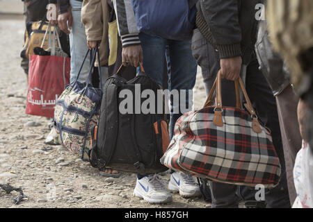 Mosul, Nineveh, Iraq. 10th Nov, 2016. 10/11/2016. Mosul, Iraq. Iraqi men, holding bags containing their possessions, wait in line as the prepare to board a bus that will evacuate them from Mosul's Gogjali District. The bus, provided by the Iraqi Army, will take them away from the fighting in the city to the safety of a refugee camp in Iraqi-Kurdistan. Credit:  ZUMA Press, Inc./Alamy Live News Stock Photo