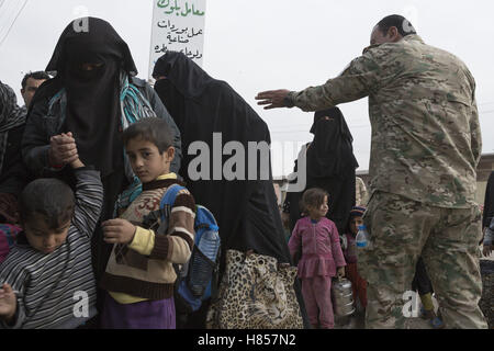 Mosul, Nineveh, Iraq. 10th Nov, 2016. Guided by an Iraqi Army major women and children, all escaping from areas within Mosul where fighting between Iraqi Security Forces and Islamic State militants are fighting, board a bus in the city's Gogjali District. The bus, provided by the Iraqi Army, will take them to the safety of a refugee camp in Iraqi-Kurdistan. Credit:  ZUMA Press, Inc./Alamy Live News Stock Photo