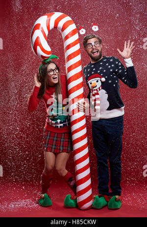 Couple standing with red and white christmas cane Stock Photo