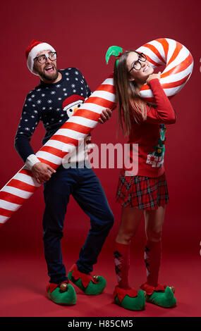 Couple carrying heavy candy cane Stock Photo