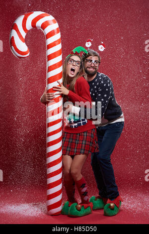 Couple next to a huge candy cane Stock Photo