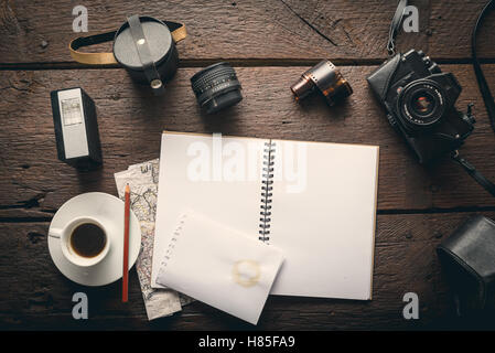 Empty notepad on the table full of photographic equipment: camera, lens, flash Stock Photo