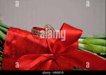 two golden rings on a bride's wedding bouquet Stock Photo
