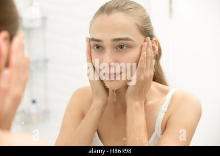 Young girl after washing her face water near the sink Stock Photo