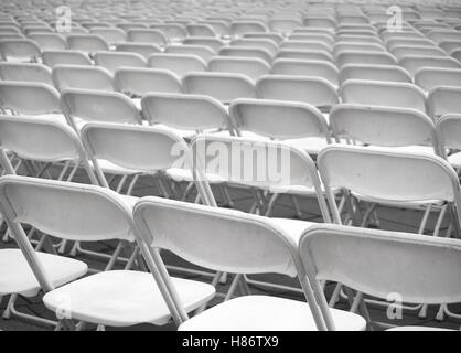 Rows of plastic chairs are set up for an outdoor  performance Stock Photo