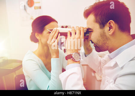 optician with pupilometer and patient at eye clinic Stock Photo