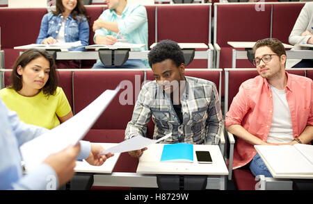 teacher giving tests to students at lecture Stock Photo