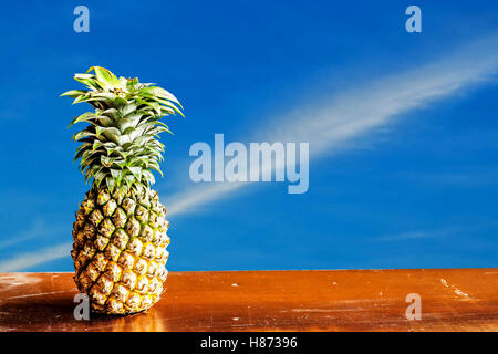 Pineapple on old wood with the blue sky. Stock Photo