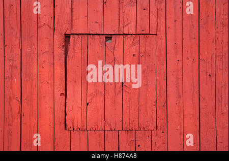 Old red wooden wall with closed square window, flat background photo texture Stock Photo