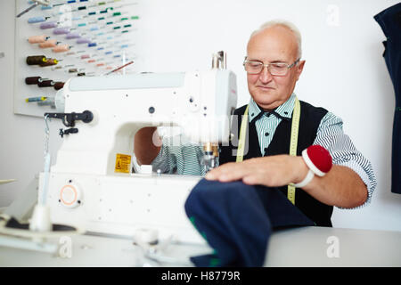 Mature tailor sewing in workshop Stock Photo
