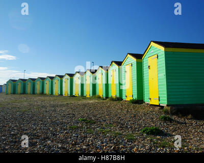 Green and yellow painted beach huts at Littlehampton, West Sussex. Stock Photo