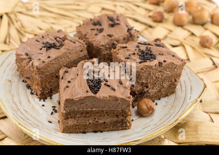 Hazelnut cake covered with chocolate cream on a plate Stock Photo