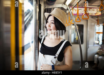 Young woman wearing a hat traveling on a train. Stock Photo