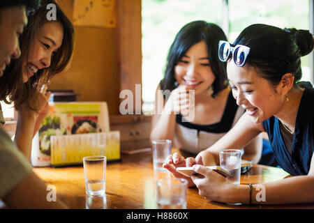 Three young women and a man sitting in a cafe. Stock Photo