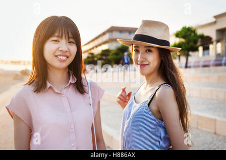 Two young women with long brown hair outside a shopping centre. Stock Photo