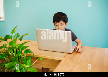 A boy using a computer in a classroom. Stock Photo