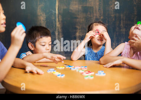 A group of children in school. Two boys and two girls holding up alphabet letters. Stock Photo